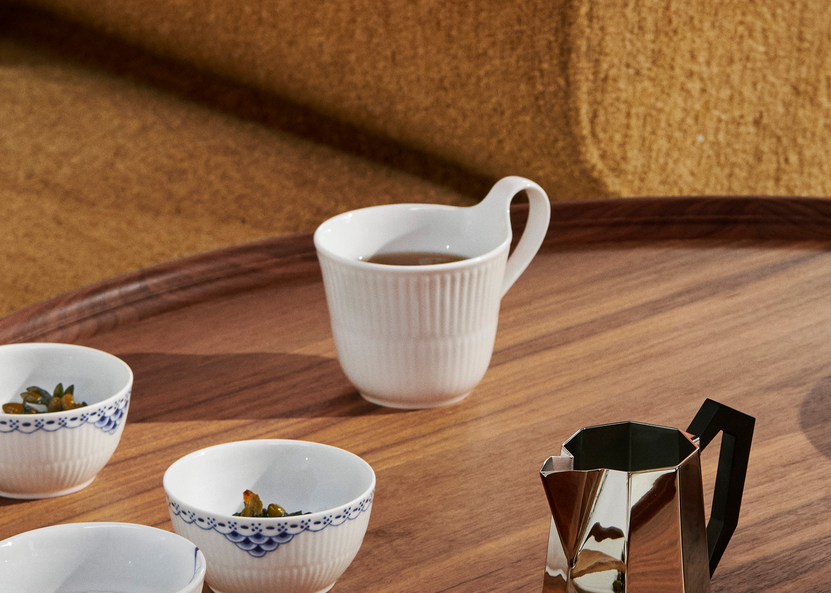 A White Fluted high handle cup from Royal Copenhagen on a coffeetable